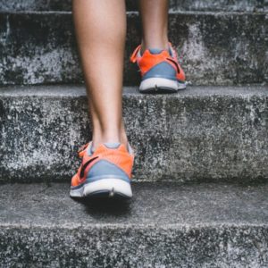 Orange and grey running shoes going up steps